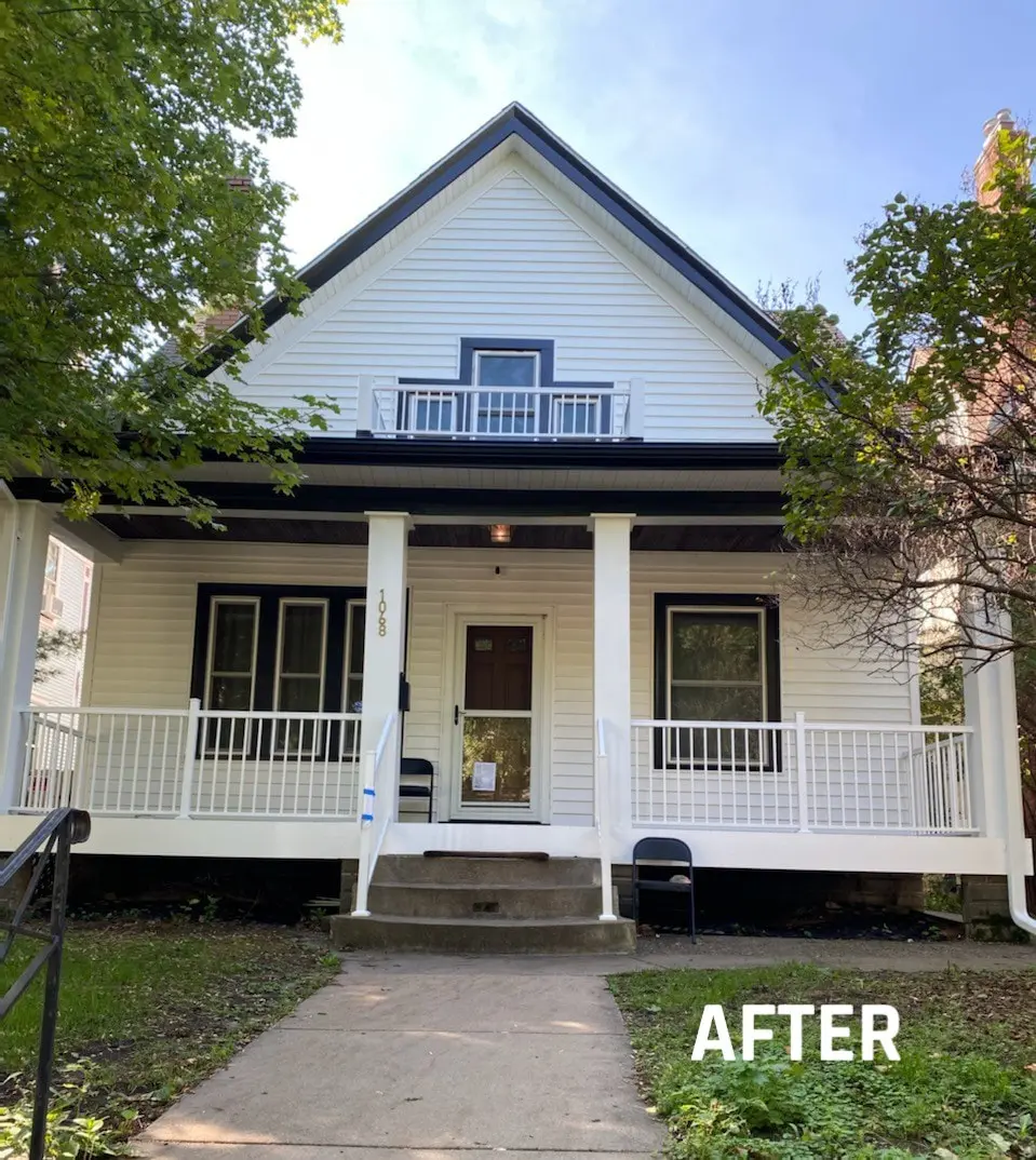 Renovated white house with porch and trees.