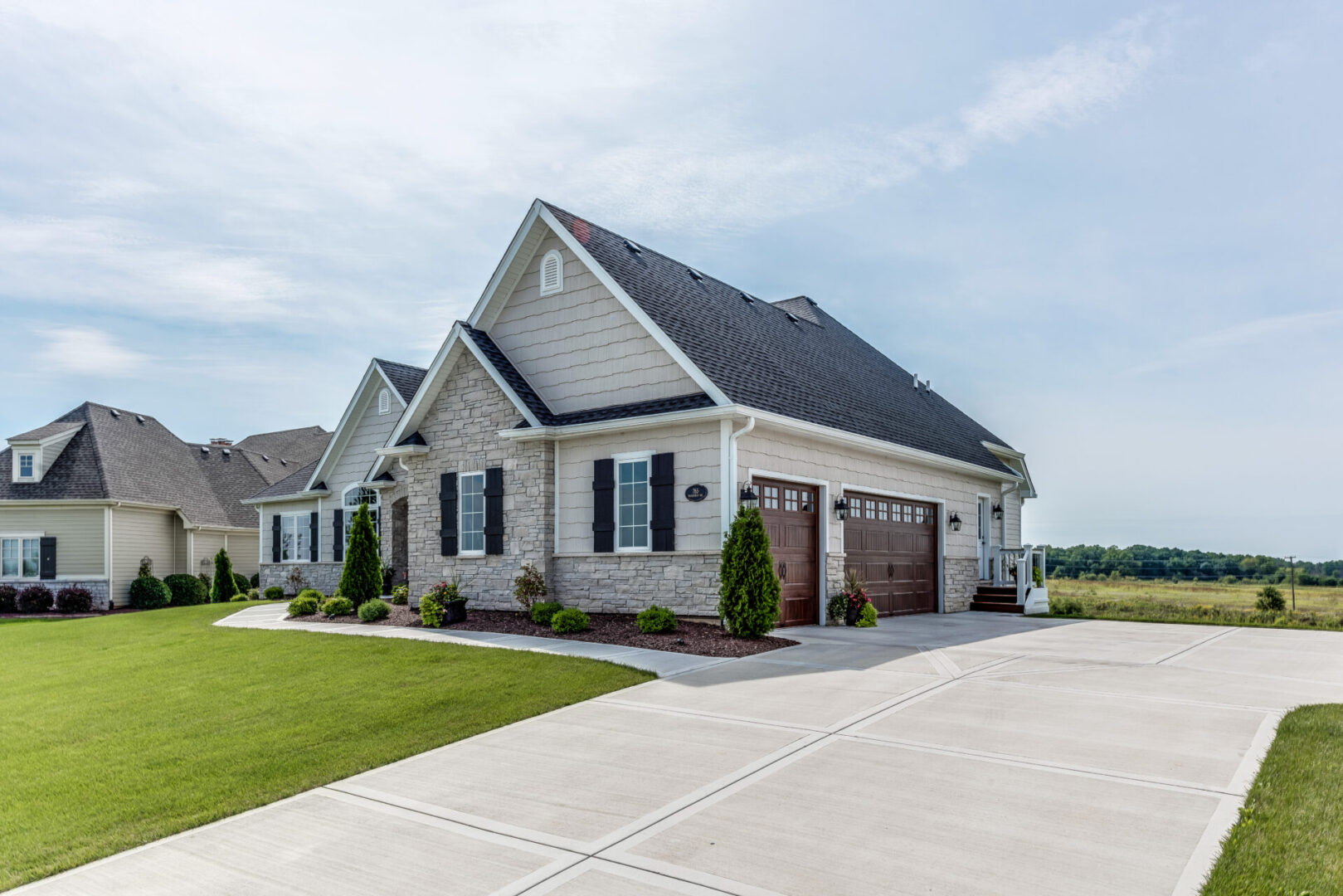 Modern suburban house with large driveway.