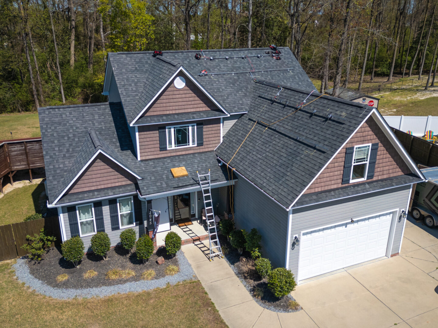 Two-story house with ladder on roof.