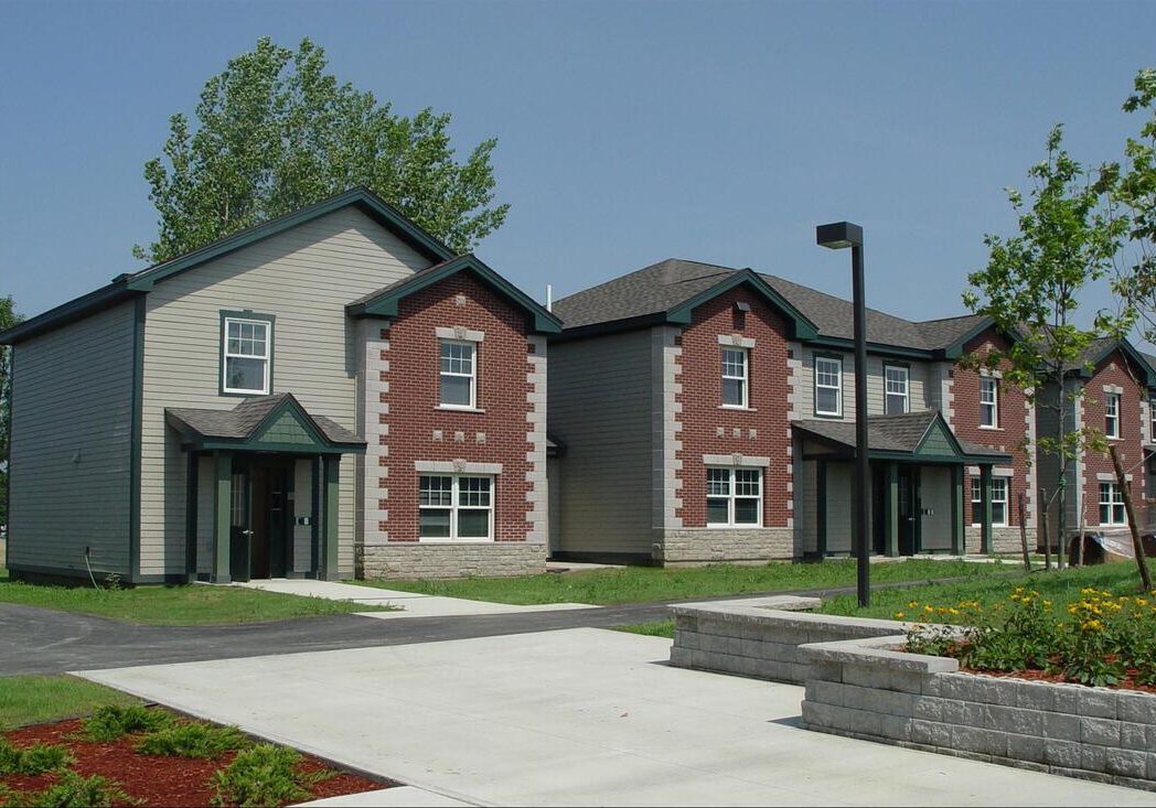 download_orig Two-story brick houses with landscaped lawns.